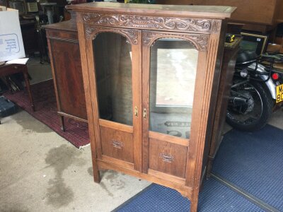 An oak display cabinet with carved design. Dimensions 94cm wide, 139cm tall, 32cm long