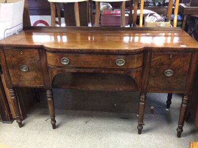 A George III mahogany sideboard with central drawers flanked by cupboards on turned legs. Length 168cm