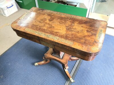 A rosewood veneered card table with brass inlay. In need of restoration. 73cm tall 90cm wide 45cm long