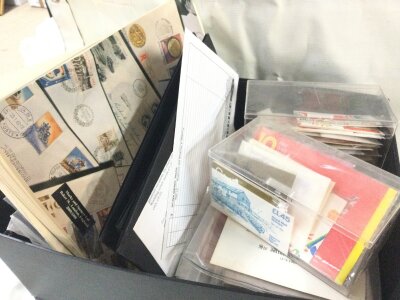 A collection of unused British postage stamps, some royal mint uncirculated and commemorative coins
