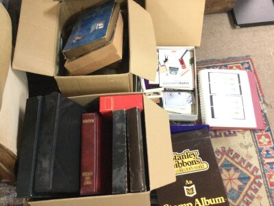 A collection of stamps including an album of Isle of Man stamps, an album of used world stamps, cigarette cards including players etc