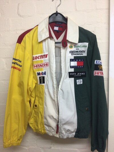 A 1994 Lotus F1 crew jacket with numerous cloth promotional badges maker Tommy Hilfiger
