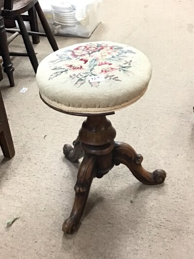 A Victorian walnut music stool with an embroidered adjustable seat on a turned column and carved splayed legs NO RESERVE
