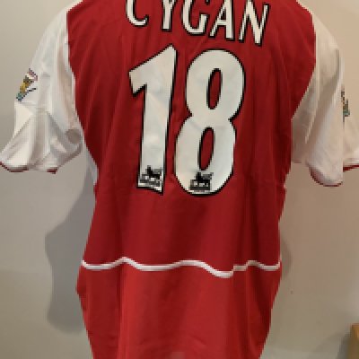 Arsenal 2002 - 2003 Match Worn Home Football Shirt: Nike red short sleeve shirt with O2 sponsorship. Cygan 18 to rear and Premier League Winners 2001/2002 sleeve badging. Inner mesh still attached. Worn by Cygan v Chelsea on 1 9 2002 with a COA signed by him.