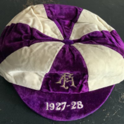 England 1927/28 FA International Trial Football Cap: Good condition purple and white cap awarded to Huddersfield Town player Roy Goodall. Goodall was capped 25 times and captained England 12 times. Rare item.