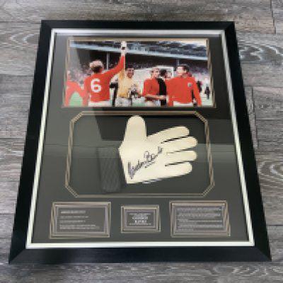 Gordon Banks England 1966 World Cup Signed Framed Glove: Beautifully framed glove hand signed by Banks with a picture of him celebrating on the pitch with team mates. Quality item which would have cost hundreds of pounds when new. Measures 58 x 68 cm.