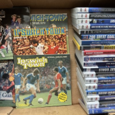 Ipswich Town Football Memorabilia Boxes: Includes 19 DVDs, Annuals, Programme binder with 10 handbooks from 49/50 to 62/63, Programme binders with more recent handbooks and magazines such as Turnstyle Blues and Town Collectables, 7 + 12 inch records, The Men Who Made Town book plus much more. (2 boxes)