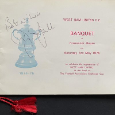 John Lyall`s 1975 FA Cup Final Football Momentos:  A signed copy of the Grosvenor Banquet Brochure, Final programme signed by Lyall plus goal scorer Taylor inside and a ticket stub with photograph also signed by Alan Taylor.  It also contains John Lyall`s personal copies of both 1975 FA Cup semi-final programmes and the ticket stub from the Chelsea match used by his son (the vendor).