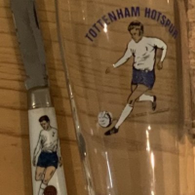 Tottenham memorabilia box: Comprises of penknife and glass from late 60s. Wine bottles (empty), mugs, rosettes, badges and records. (21)