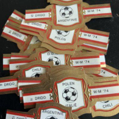 Football Cards + Memorabilia: 1974 Victor Calendar, 1966 World Cup Willie advert, Bob Wilsons incomplete Soccer Action album, Complete set of 24 1974 World Cup cigar bands and a further set with one missing.