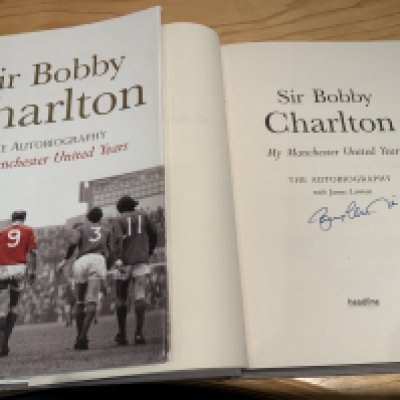 Bobby Charlton Multi Signed Manchester United Football Book: Sir Bobby Charlton Manchester United Years signed inside by himself. Also on first blank page it is signed by some of his Man Utd team mates to include Foulkes Crerand Stepney Aston Dunne Sadler Law and Stiles. All without dedication.