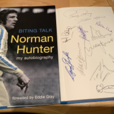 Norman Hunter Leeds United Multi Signed Football Book: Excellent hardback book with dust jacket signed on one page by Hunter and on inner page by 12 team mates including Clarke Reaney Jones and Sprake.
