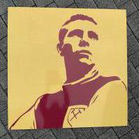 Bobby Moore Large Display From Upton Park. Removed from the Boleyn Ground after its close in 2016. Very large claret and yellow art display featuring Bobby Moore in West Ham kit. Measures approximately 39 inches each side. Not for posting.