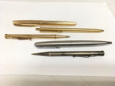 Two Parker pens, a silver propelling pencil and one other pen.