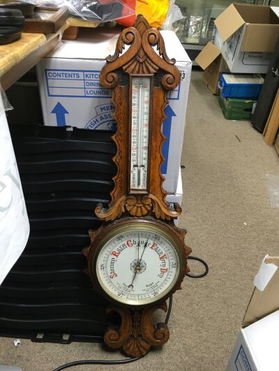 A carved oak barometer.