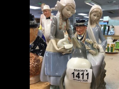 Lladro comprising two figures and a penguin.