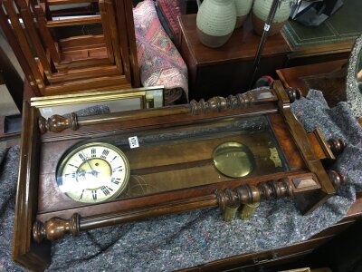 A wall clock with a walnut case, turned columns, brass movement, weights and pendulum. Case 102cm tall , 44cm wide.