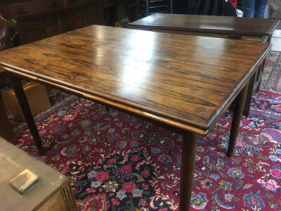 A mid 20th century rosewood dining table with extending leaves. Dimensions 130cm wide 86cm long 75cm tall