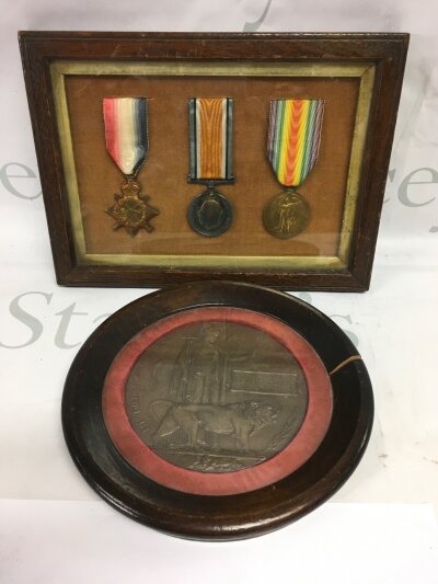 A framed WW1 medal group and a framed death plaque in memorium of Edward Clarke.
