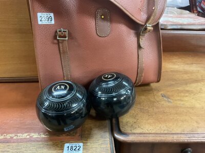 A leather case containing bowling balls .
