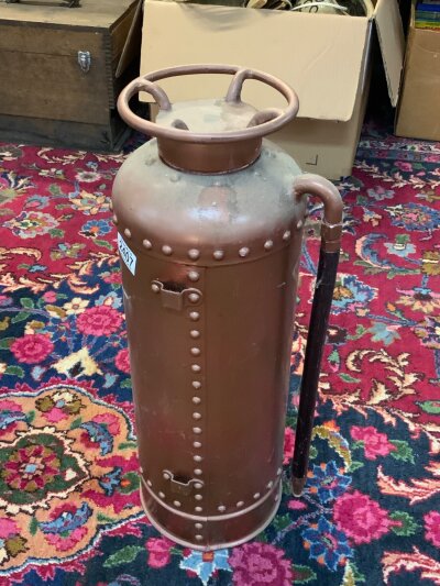 A vintage copper fire extinguisher.