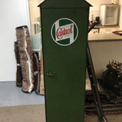 A rare Vintage  Castrol work shop oil storage cupboard with a peaked top the single door with brass fittings enclosing a racked interior for three large oil cans the exterior finished in green with a red interior Hight 175cm width 52cm  