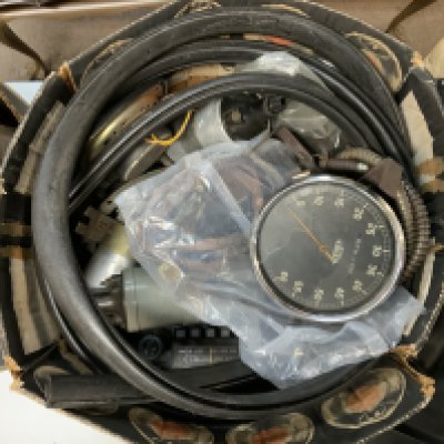 A vintage tin trunk and boxes containing a quantity of Vintage and classic  car parts.