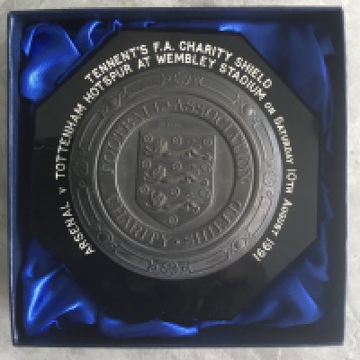1991 Tottenham v Arsenal Charity Shield Football Plaque: Lovely plaque with match details surrounding the Football Association Charity Shield with 3 Lions inner circle. This style has been used for many decades and the same plaque with given to both teams and they never had winners or runners up on them. This was awarded to Spurs club secretary Peter Barnes and was the last Charity Shield with shared winners.