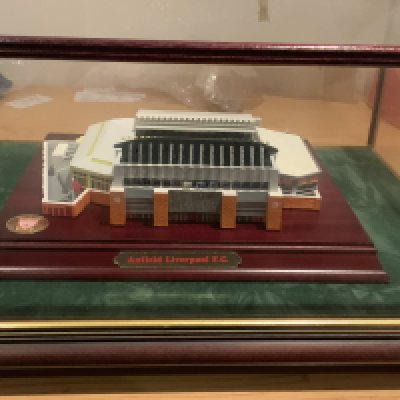 Liverpool Anfield Football Stadium Model: Lovely detailed stadium model in glass case measuring 16 x 13 and about 7 inches high. C/W certificate and two pieces of rock from the old Spion Kop end. C/W hand signed card with autographs to include Houghton Rush and Grobbelaar.