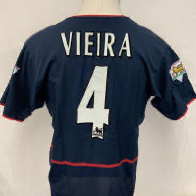 Arsenal 2002 - 2003 Match Worn Blue Football Shirt: Short sleeve blue away kit with Premier League badging to sleeve stating Champions 2001 - 2002. Vieira number 4 to rear. 02 sponsor. Signed COA stating I wore this shirt v Leeds on September 28th 2002. Press photo of him wearing this shirt.