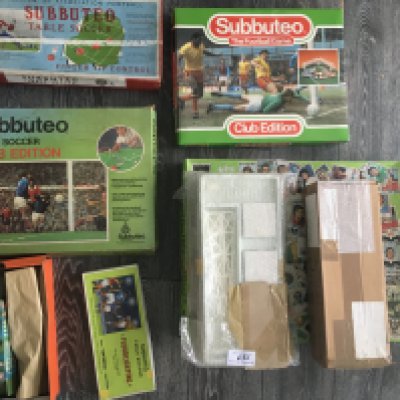 Subbuteo Football Games + Accessories: Two Club Editions, another covered in football stickers and one older looking Subbuteo boxed game. C/W floodlighting. All boxes and lighting unchecked for contents.