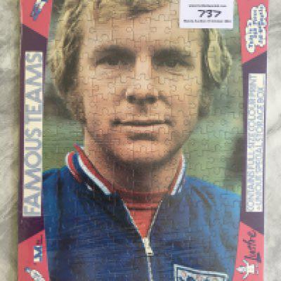 Bobby Moore West Ham + England Jigsaw Puzzle: Still sealed and in packaging featuring Moore in England tracksuit top made in the 70s by Lustre. 250 pieces. Rare poster to rear as guide for making up.