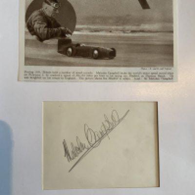 Malcolm Campbell Signed Mounted Land Speed Record Display: In 1931 British born Campbell reached a speed of 246 miles per hour in his bluebird car and was later knighted. Autograph on cream paper and cutting featuring him with car mounted on white card. C/W some other cuttings and pictures.