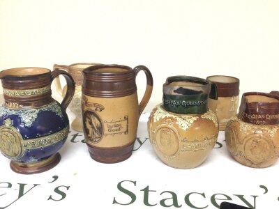 A collection of Doulton stoneware Victorian jugs Jubilee commemorative one with a silver collar. One stamped Thomas Wallis Holborn Circus. (6)