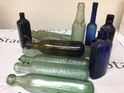 A collectof 19th century glass bottles including blue glass bottles an unusual Day Son & Hewitt Chemical Extract London bottle black glass Barrett & Co London Moorhouse Champange Cider green Glass Webbs of London and others. NO RESERVE.
