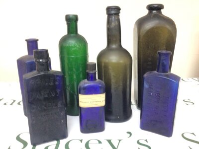 A collection of 19th century bottles including a very early green wine bottle Dutch Gin bottle blue glass Poison bottles Prices Patent Candle Company Pitts Imperial Hair Renewer a green bottle Harrogate Royal Pump Room