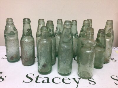 A collection of Victorian and later glass Codd bottles all with moulded trade labels. NO RESERVE.