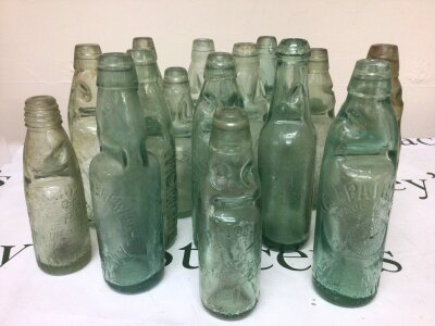 A collection of Victorian and later Glass Codd bottles each with moulded trade labels.