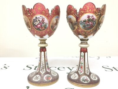 A pair of Victorian cranberry glass and enamel lustres (damaged). 26cm tall