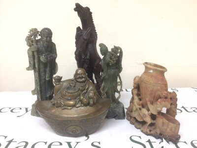 A collection of Chinese and Asian ornaments including a brass figure with seated buddha green and other soapstone carvings and carved hardwood ornament in the form one two rearing horses