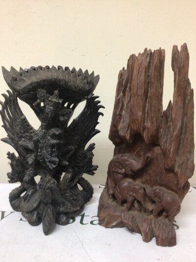 A carved hardwood Balinese Hindu figure group of the Deiety Vishnu riding his mount Garuda and a hardwood carving of naturalistic form three elephants Height 43cm
