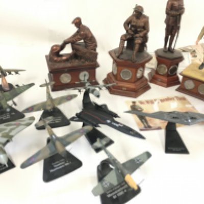 A collection of miliatary model memorabilia relating to various wars including ww1 and ww11. Includes model aircraft. Includes 6 Danbury Mint sculptures mostly with coins.