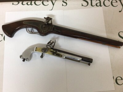 A Replica Wheel lock pistol with a full length mahogany stock and unusual Aluminium and brass replica flint lock pistol non firing ornaments. (2)