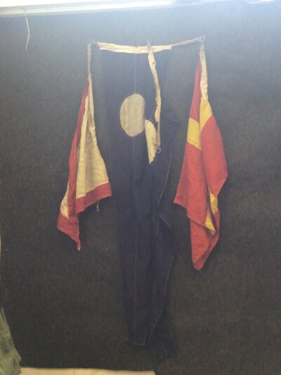 A German Third Reich Provincial flag with hand painted Swastika and other Marine signaling flags.