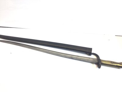 A French Yataghan 1874 pattern bayonet with a brass grip hook quilon matching serial numbers to the scabbard and standard engraved edge.