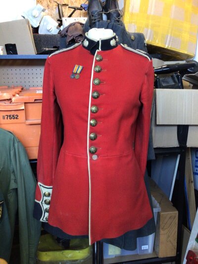 A British Grenadier Guards scarlet number one dress tunic with attached First World War, miniature medals.