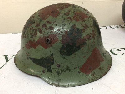 A Steel combat helmet possible Bulgarian with camouflage brown and dark green paint leather lined interior and possibly II world war.