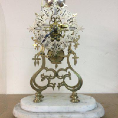A Victorian brass skeleton clock striking on a bell under glass dome on marble base . 48 cm With key and pendulum.