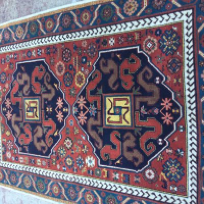 A Kazak Rug with central geometric design and floral boarders . 212 x 142 cm .