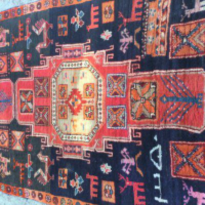 A Persian geometric and animal design runner if a red an blue field. 215 x 118 cm .